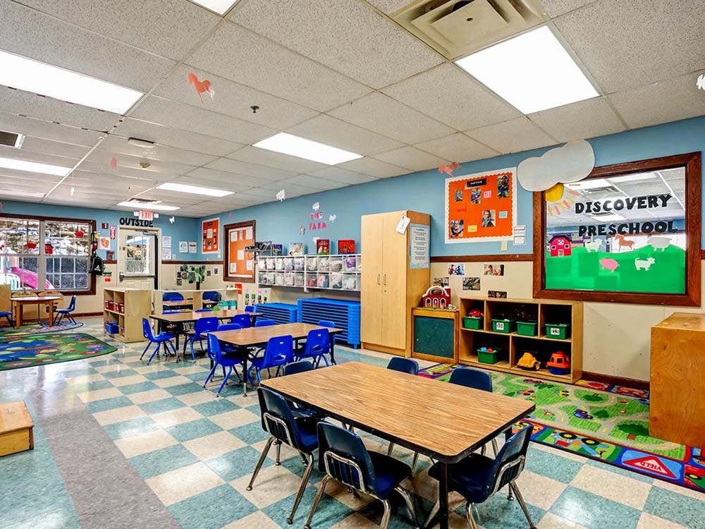 Colorful preschool classroom with small tables and chairs
