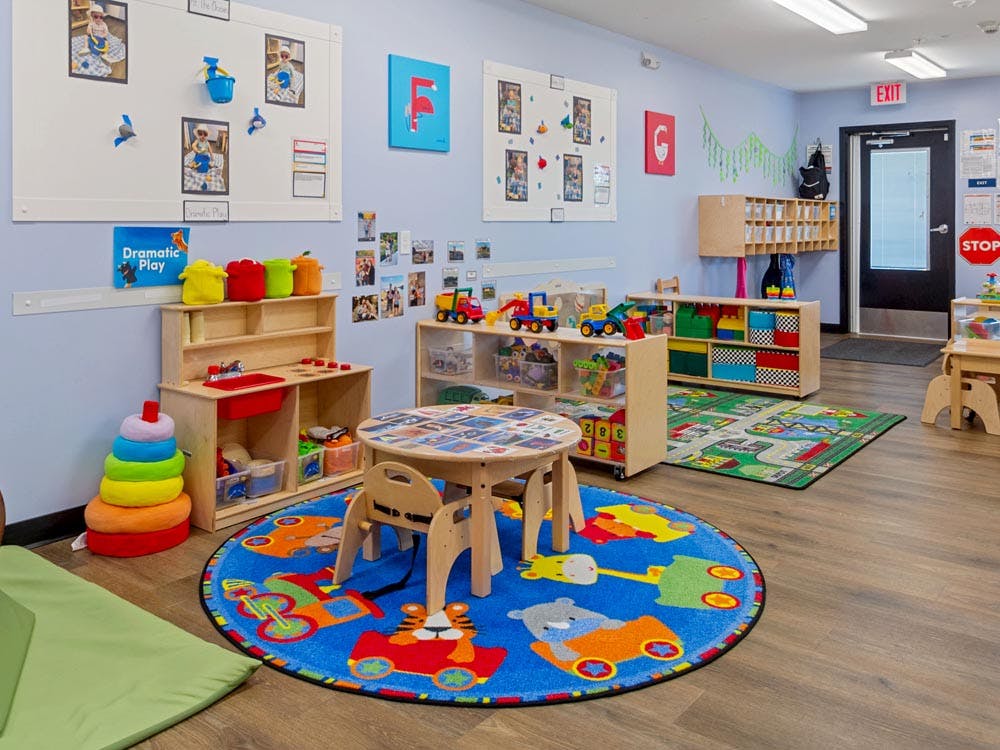 Children's classroom with small tables, chairs, and play kitchens