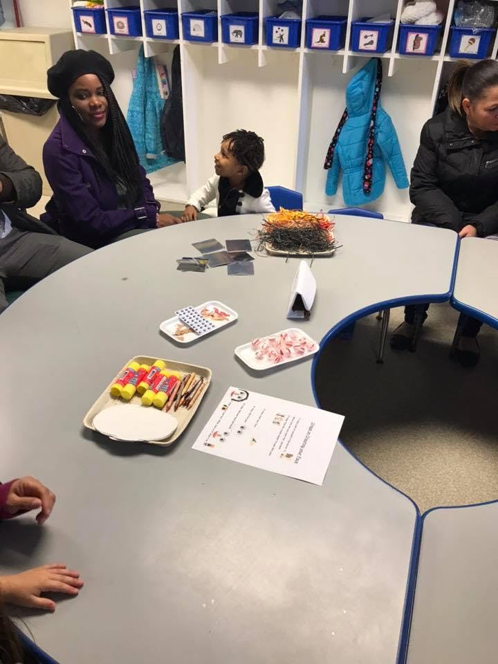 Adults and a child sitting at a table with craft supplies