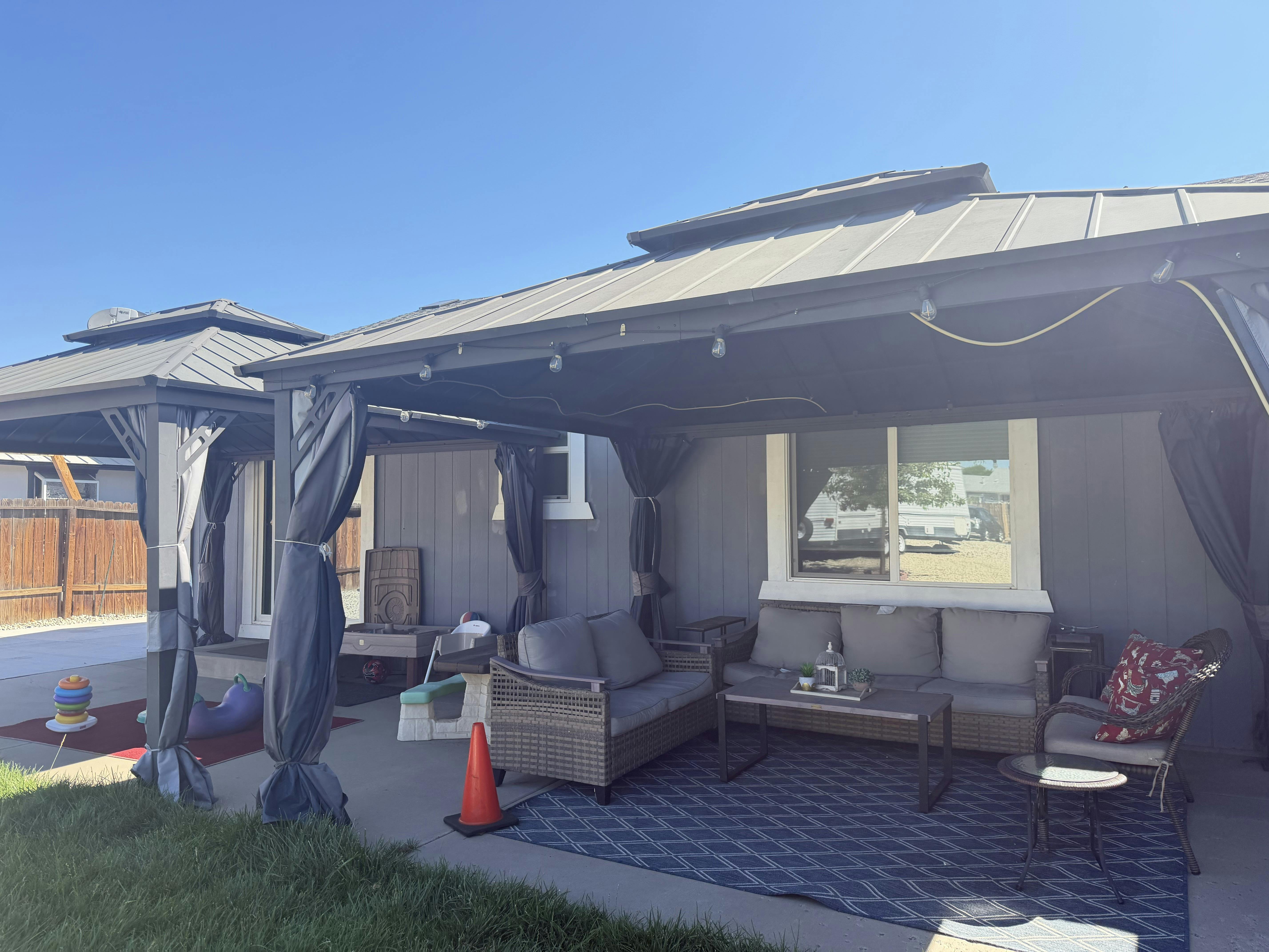 Patio furniture and a gazebo in a backyard setting
