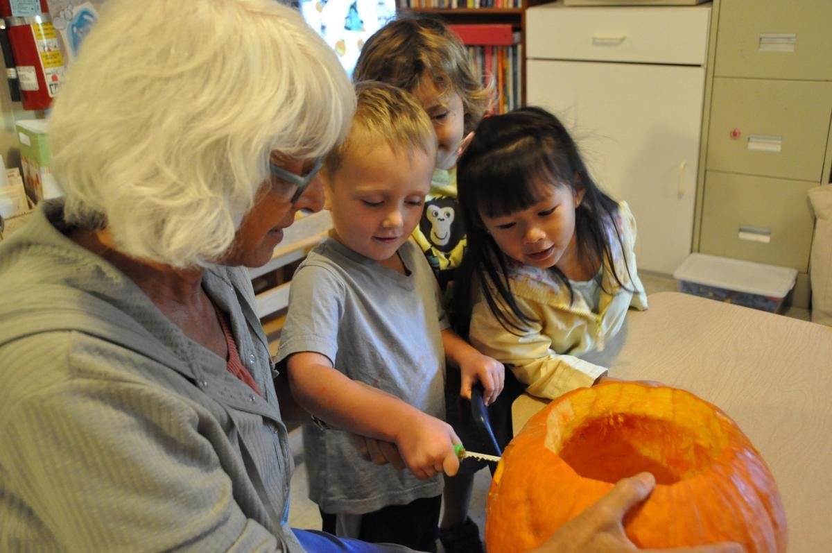 Person and children carving a pumpkin