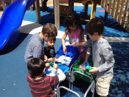 Children playing with water and toys in a play area