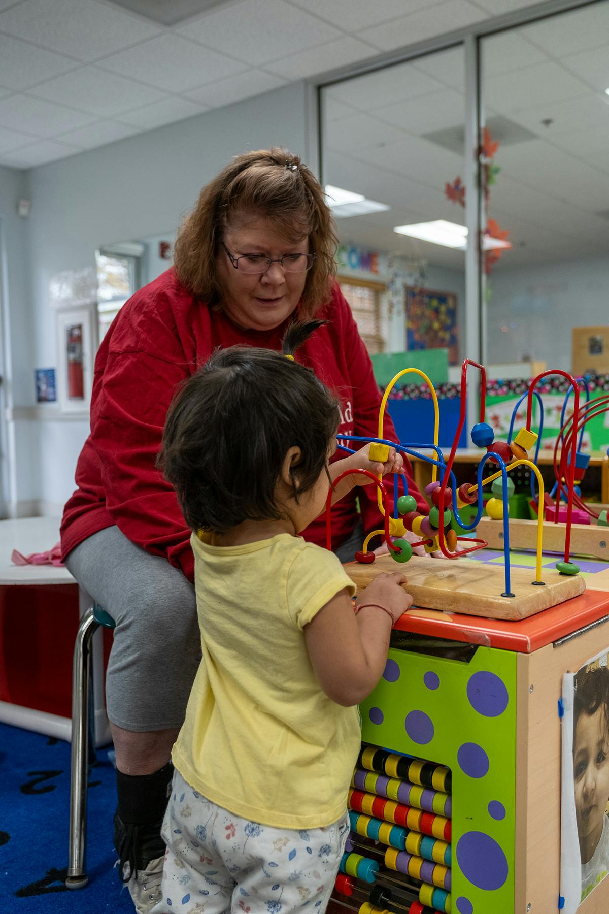 Person and child playing with a bead maze toy