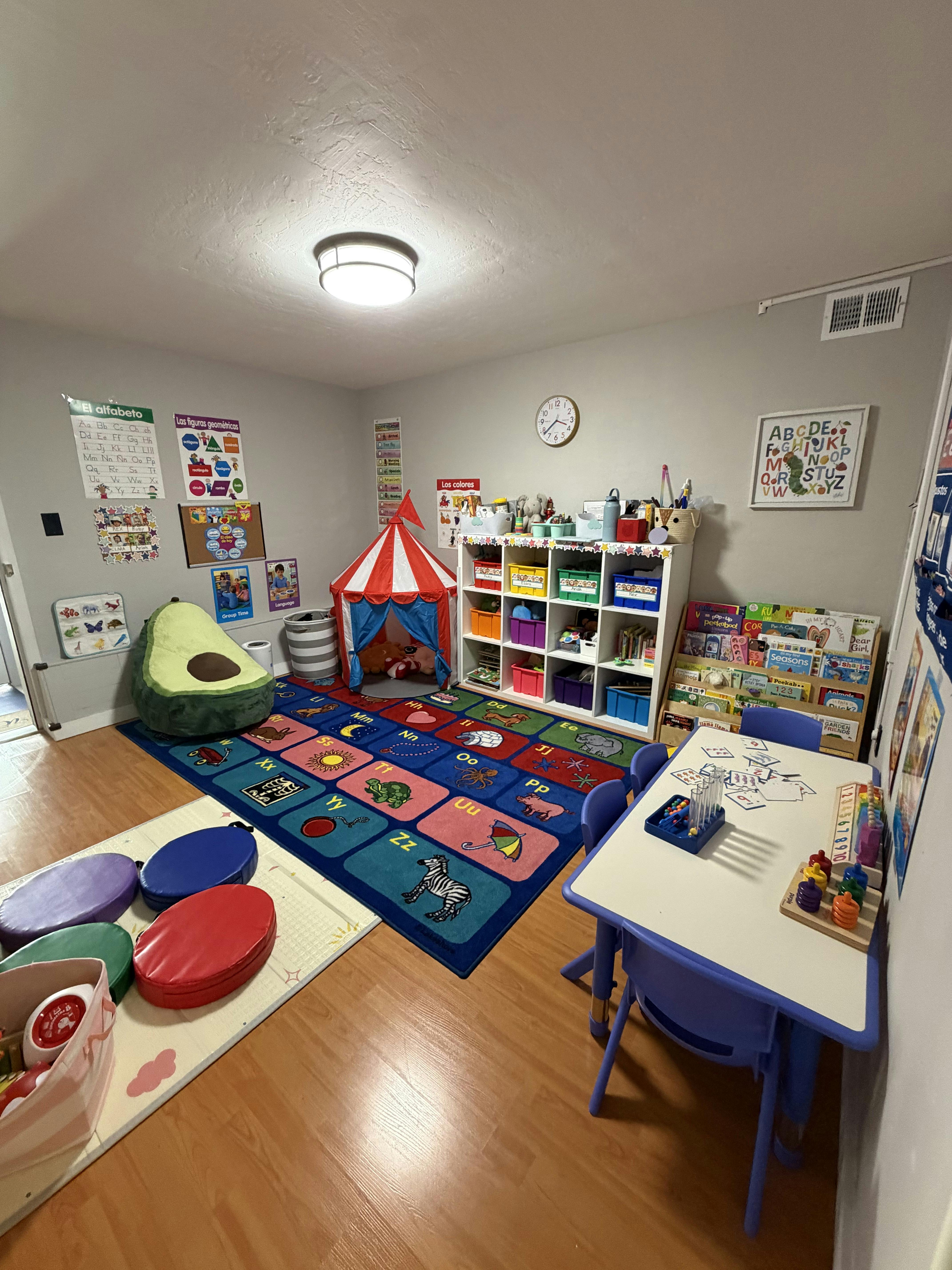 Educational playroom with alphabet rug, play tent, and child-sized furniture