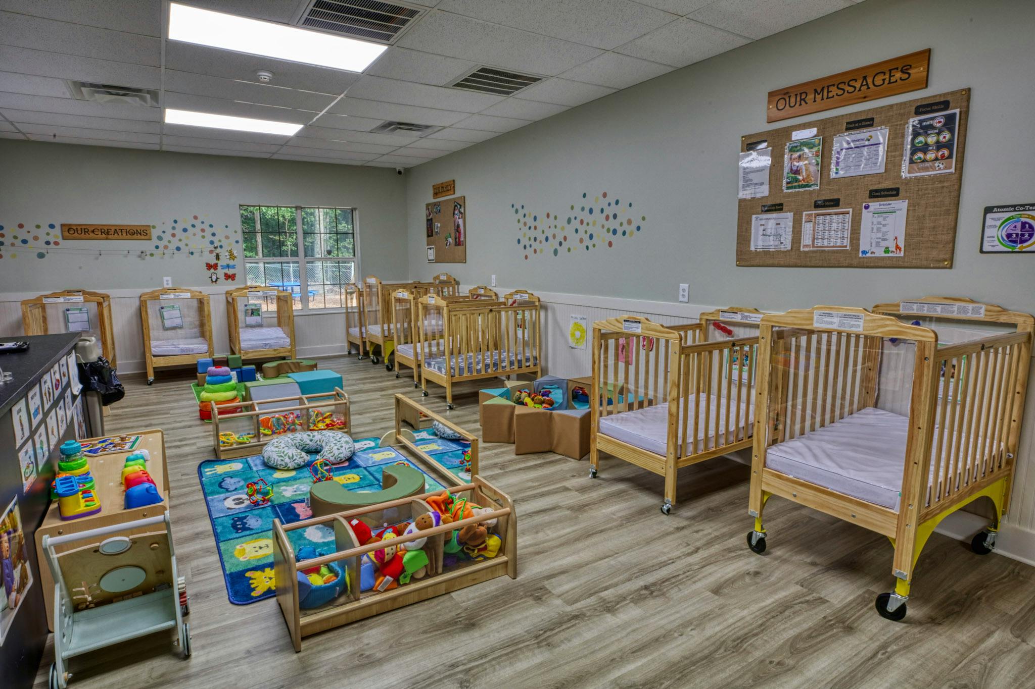multiple wooden cribs in a room with toys and playmats