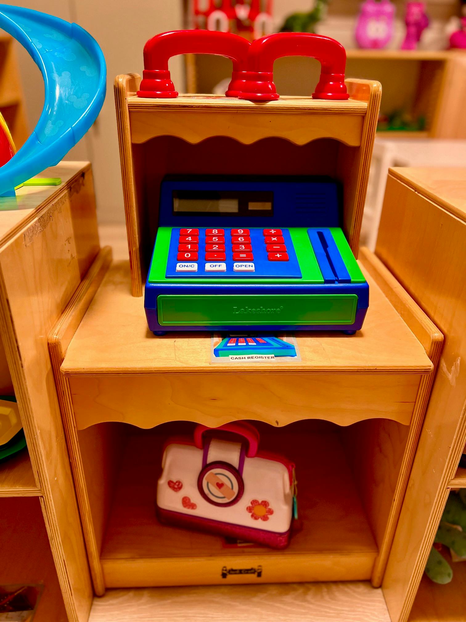 toy cash register on a wooden shelf