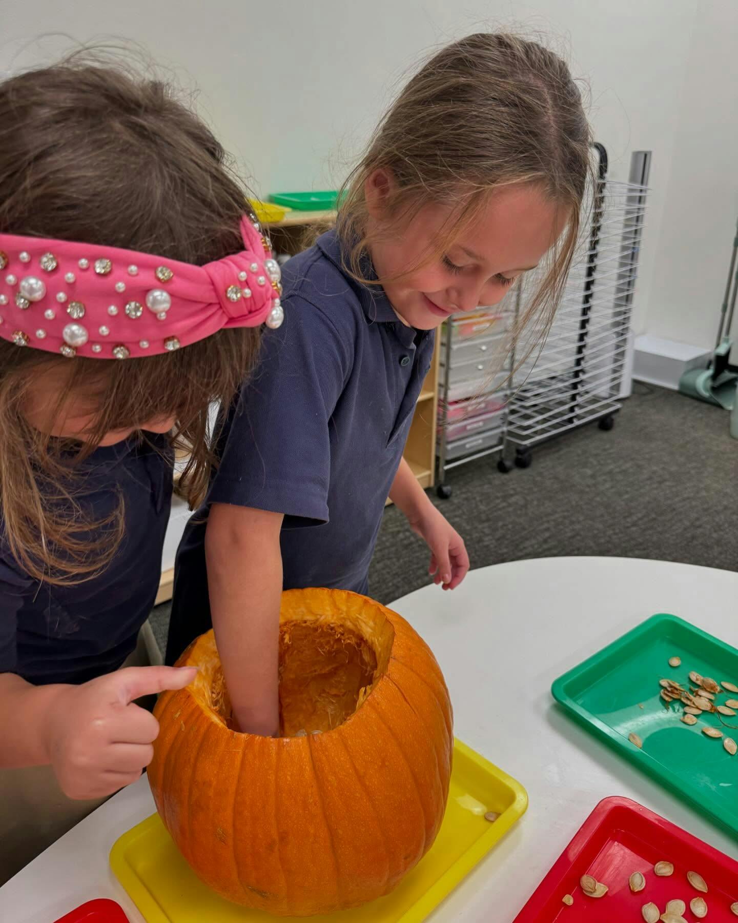 Two children carving a pumpkin
