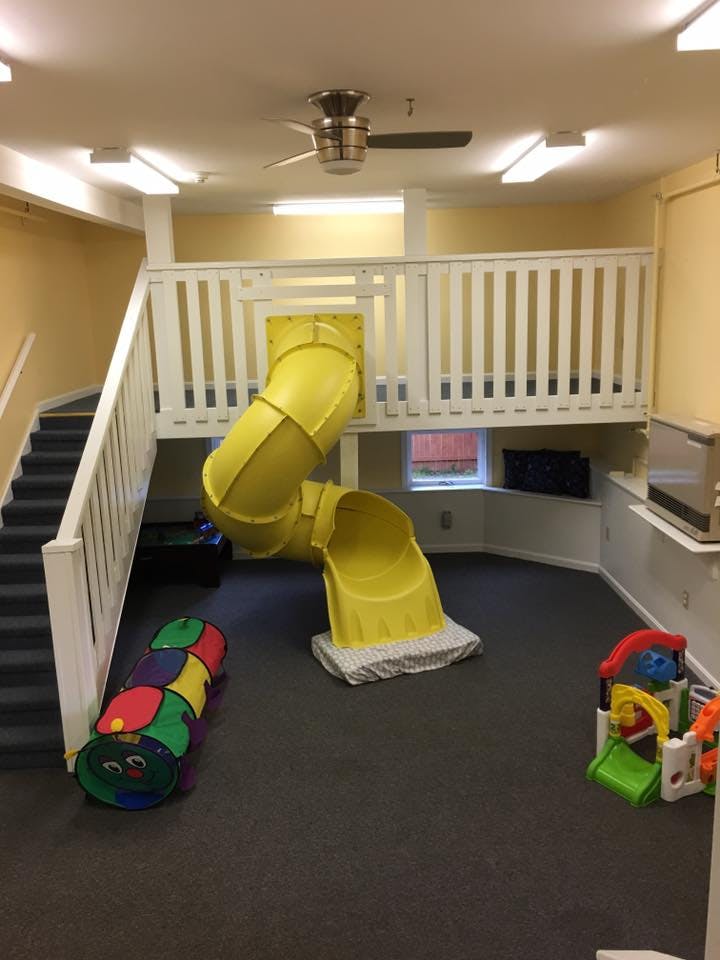 Indoor play area with a yellow slide coming from a raised platform