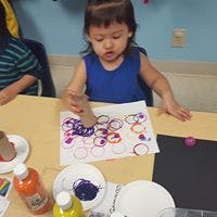 Child painting with a cardboard tube