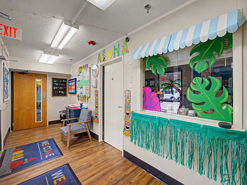 Hallway decorated with a bulletin board, chair, and a window display