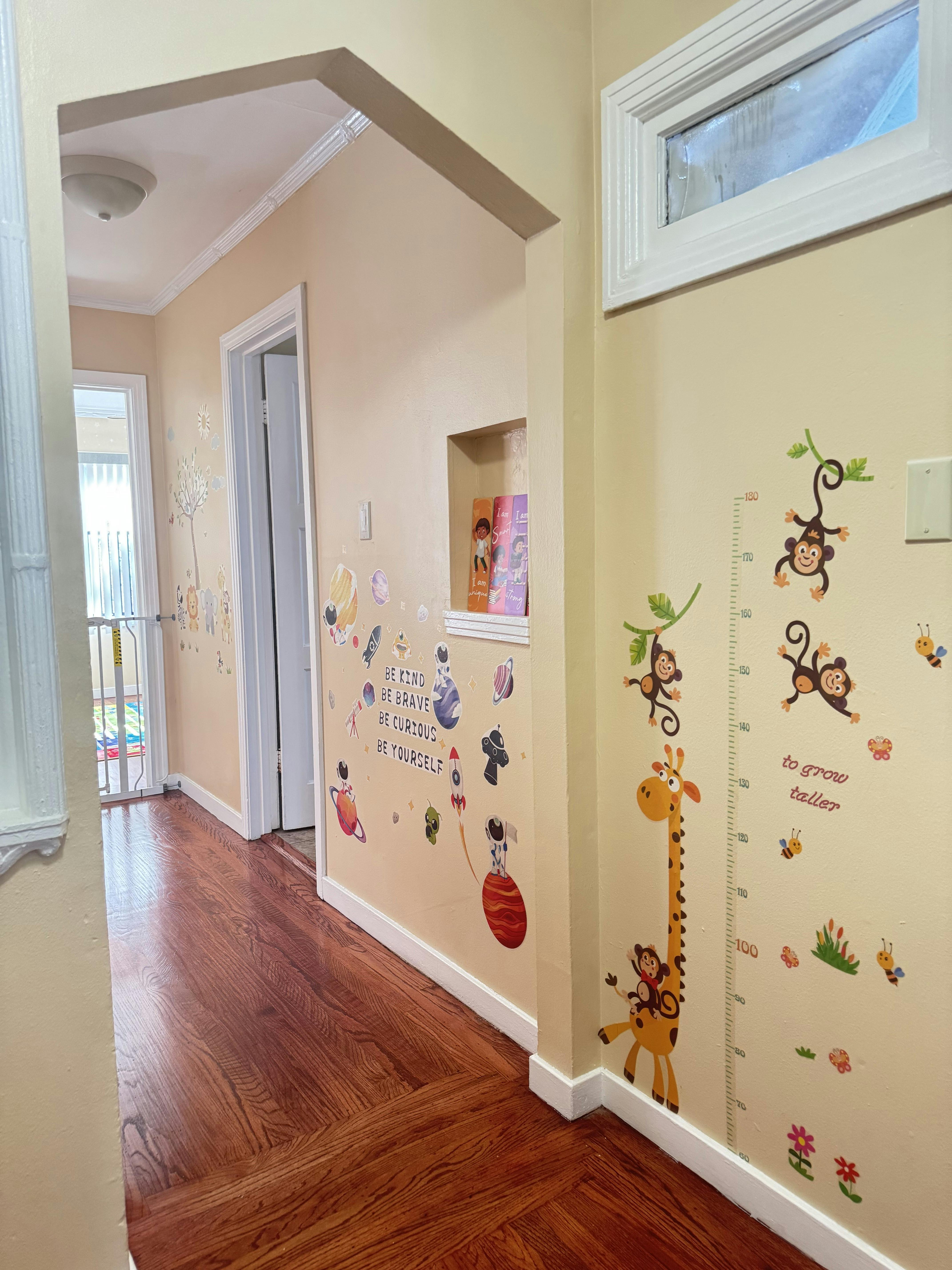 Hallway with wall decals of animals and a growth chart
