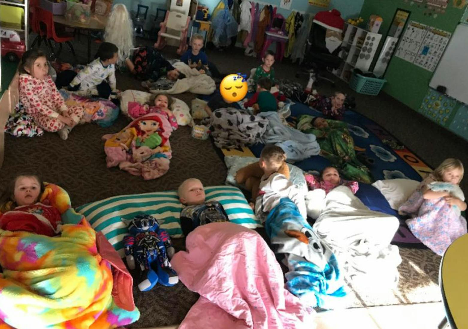 Children resting on blankets and pillows on the floor