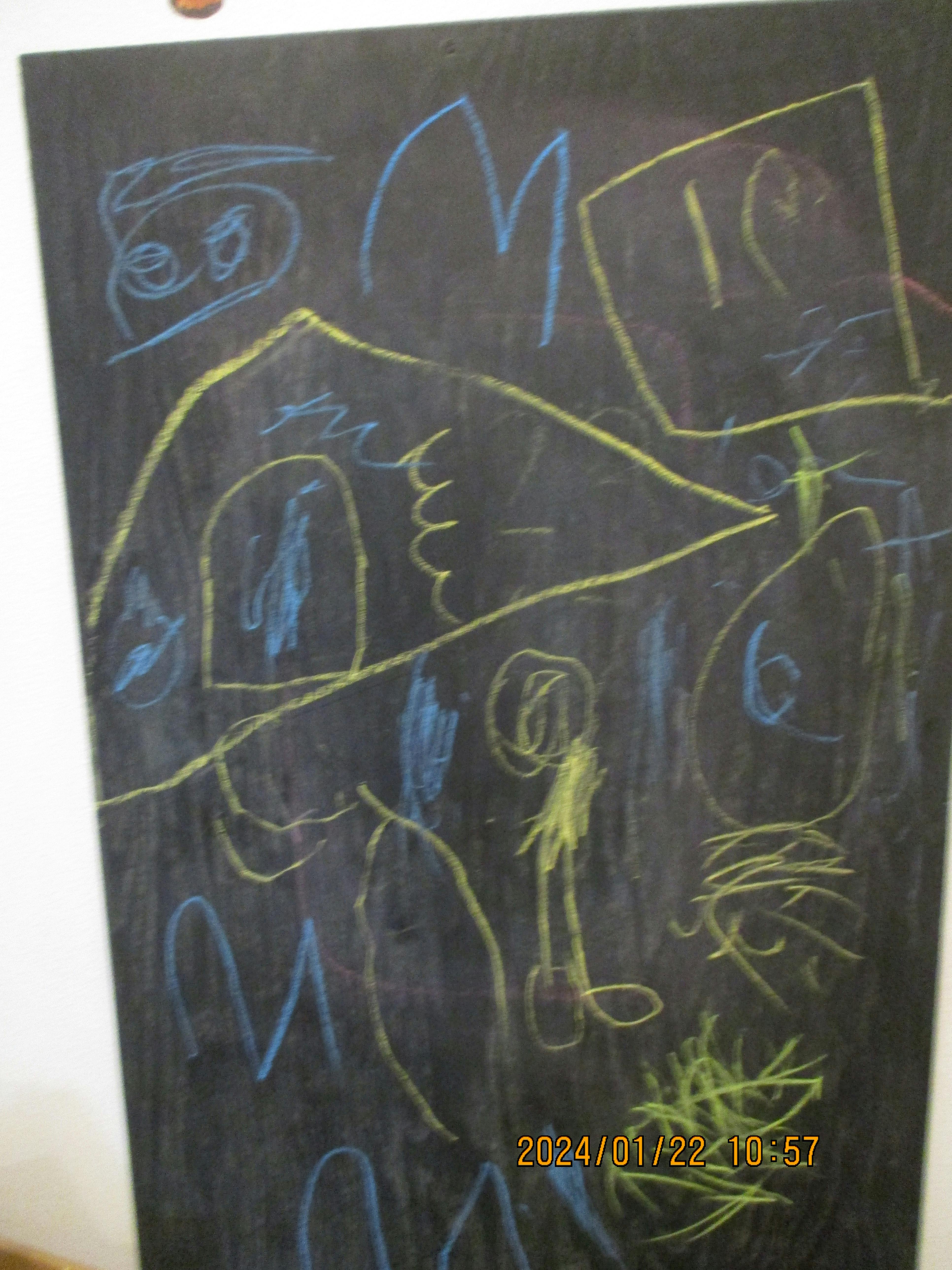 Chalkboard with various abstract drawings in blue and yellow chalk