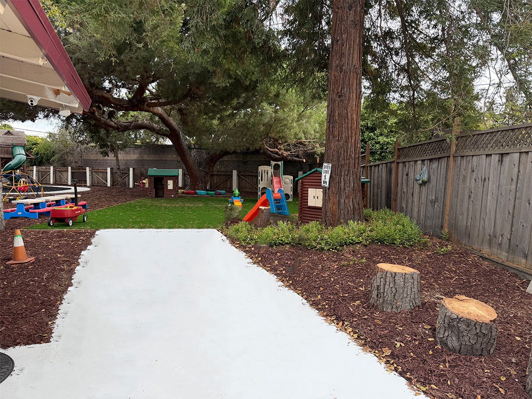 Outdoor play area with a path, grass, and play structures