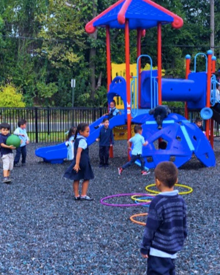Children playing on a playground with a slide and climbing structure