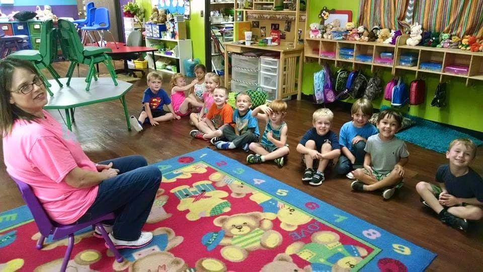 Adult and children sitting on floor in classroom