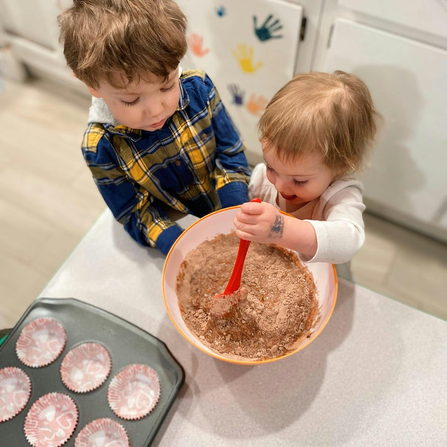 Two children mixing ingredients in a bowl