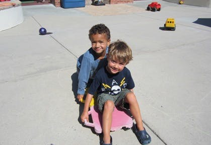 Two children sitting on a toy