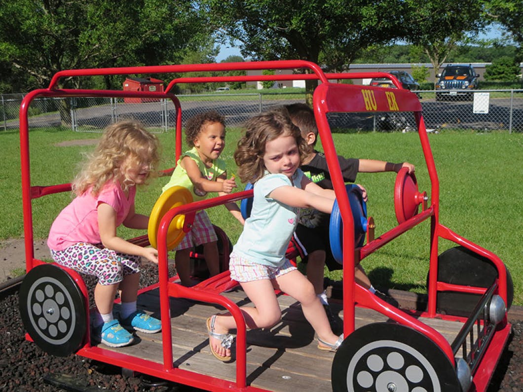 Children playing on a red toy truck