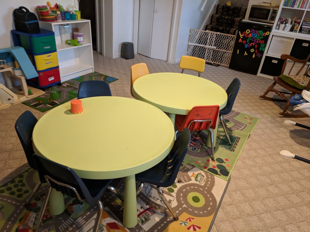 Two round tables with chairs in a room with a rug