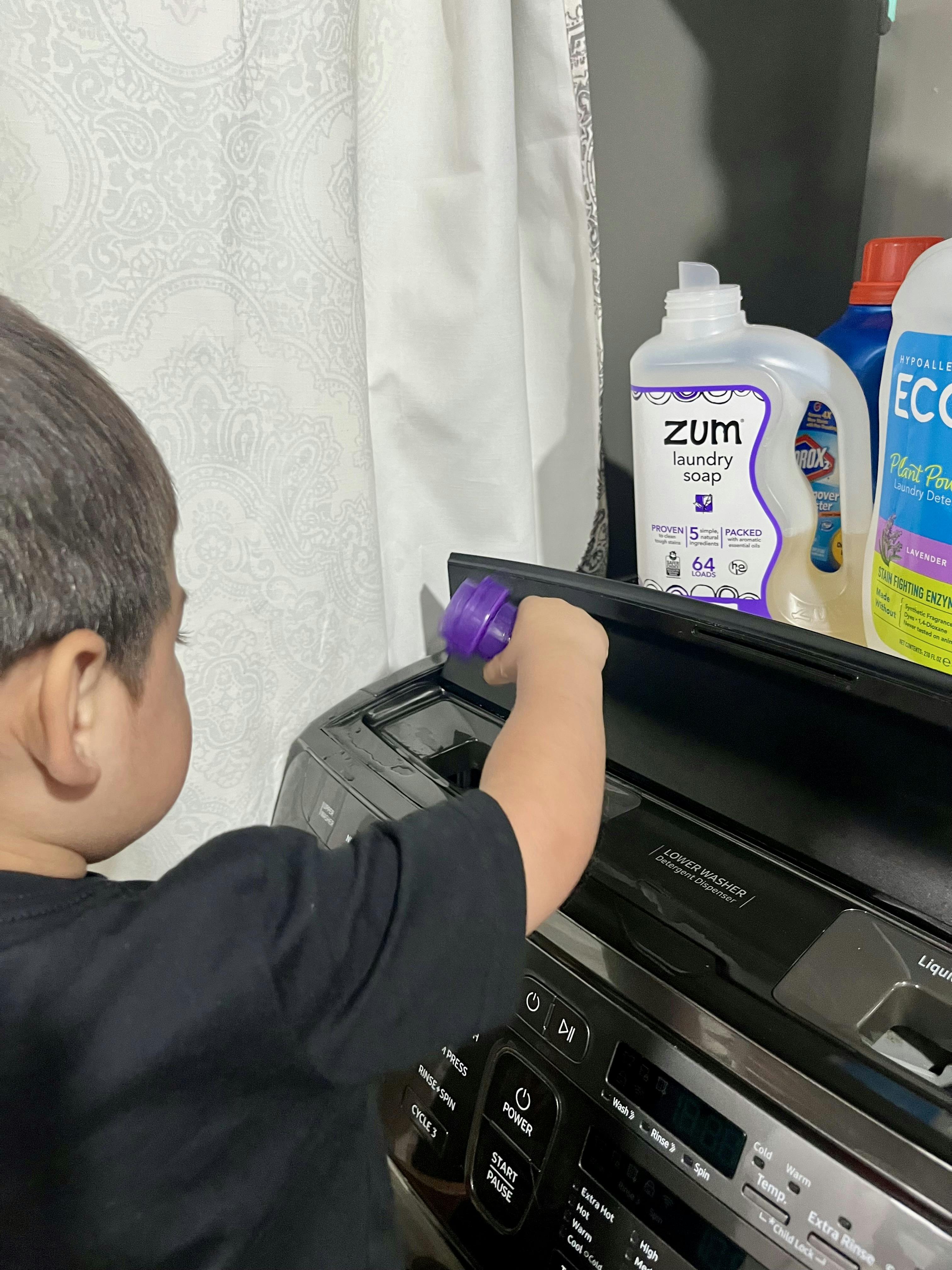 Child pouring laundry detergent into a washing machine dispenser