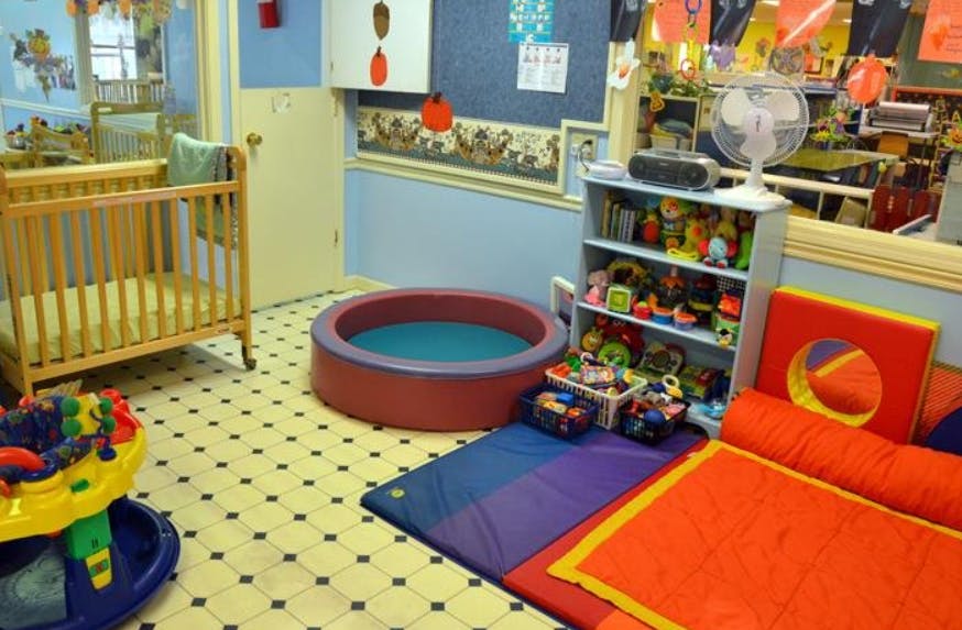 Crib, playpen, and play mats in a room