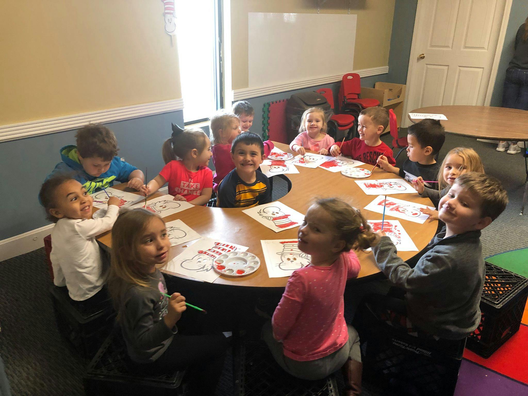 Children sitting around a table coloring and coloring