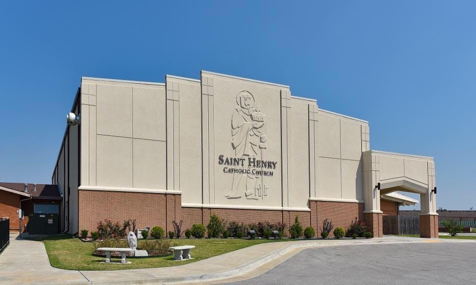 Saint Henry Catholic Church building exterior with a statue and text on the facade