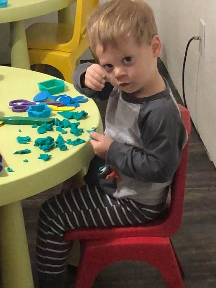 Child sitting at a table with play-doh