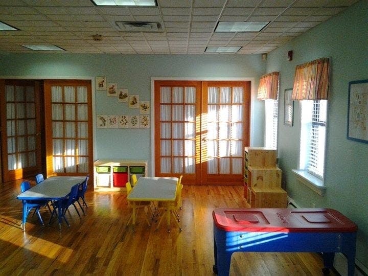 Classroom with small tables and chairs, light streaming through windows