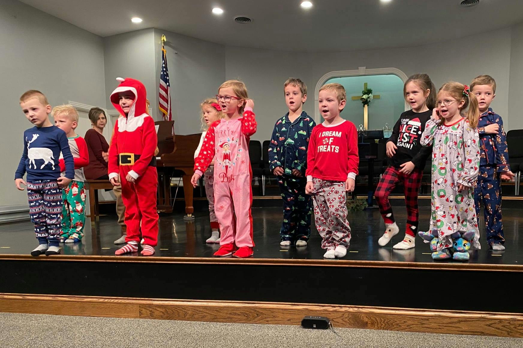 Children in pajamas standing on a stage