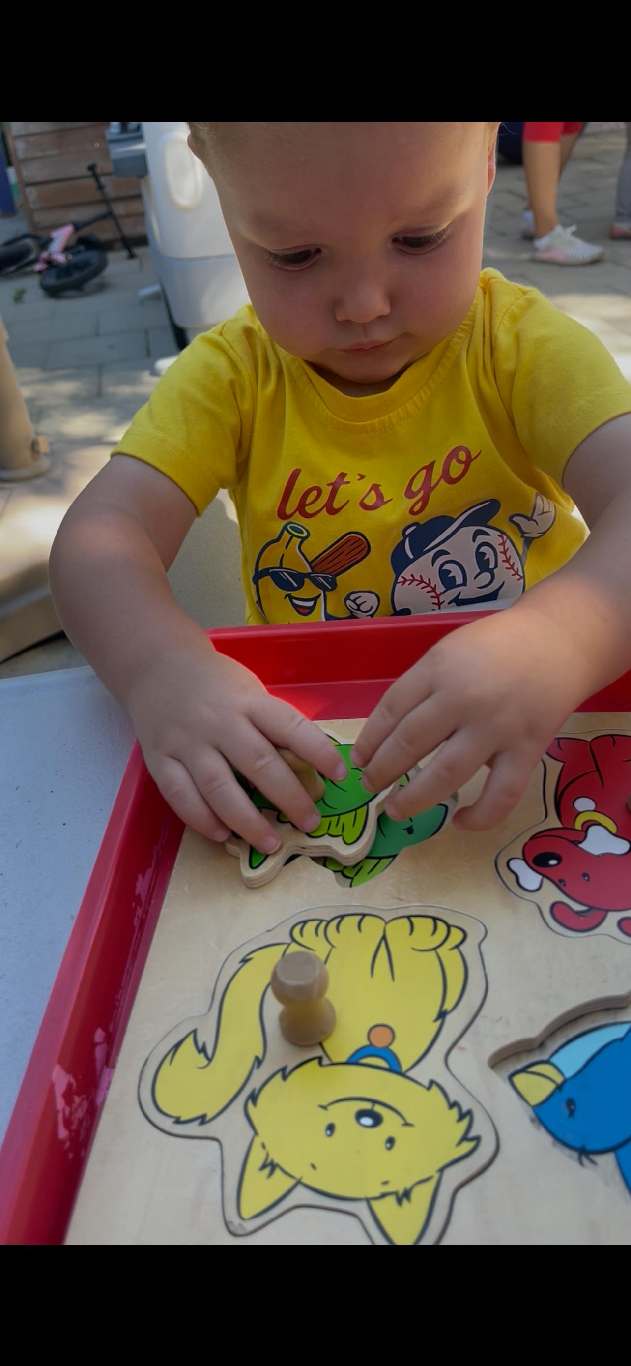 Child playing with a wooden peg puzzle