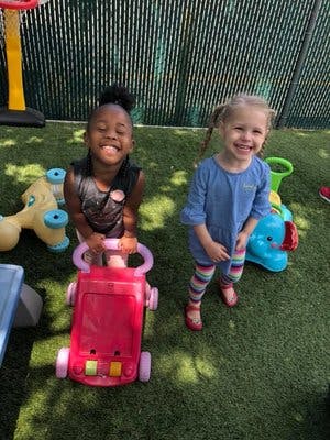 Two children playing with toys on grass