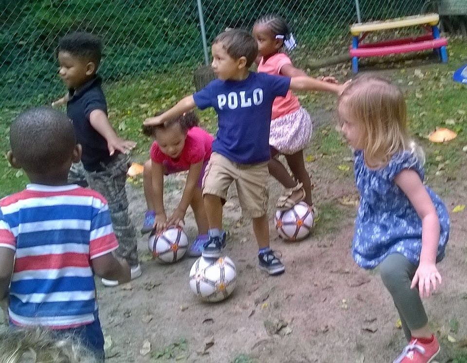 Children playing with soccer balls outdoors