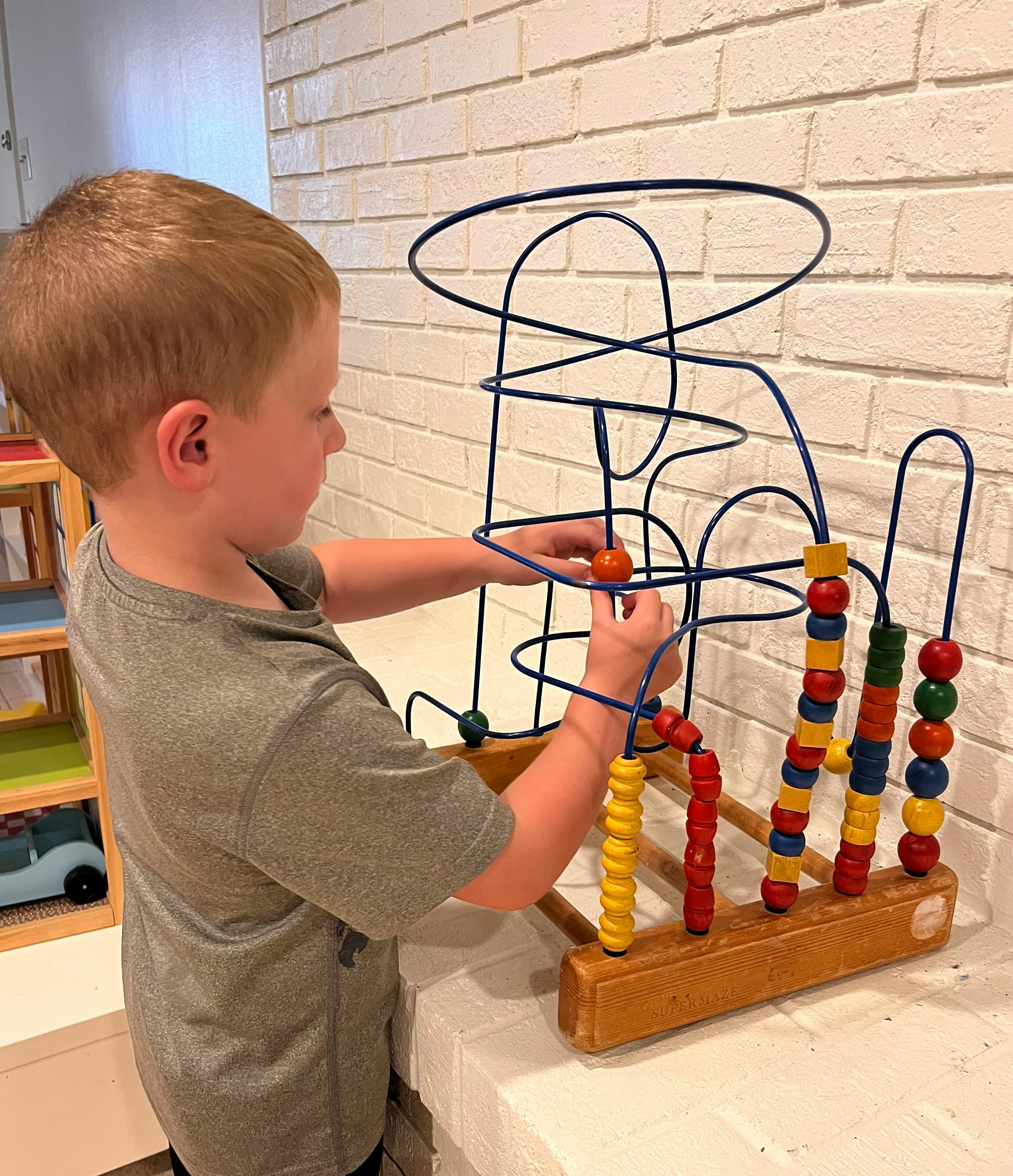 Child playing with a bead maze toy