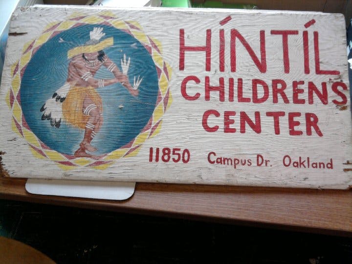 Wooden sign for Híntíl Children's Center with a person dancing