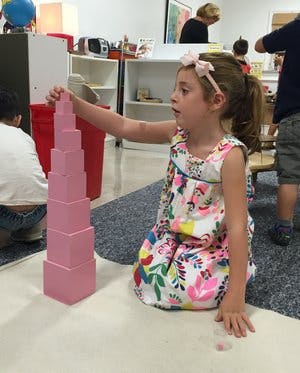 Child building a tower with pink blocks
