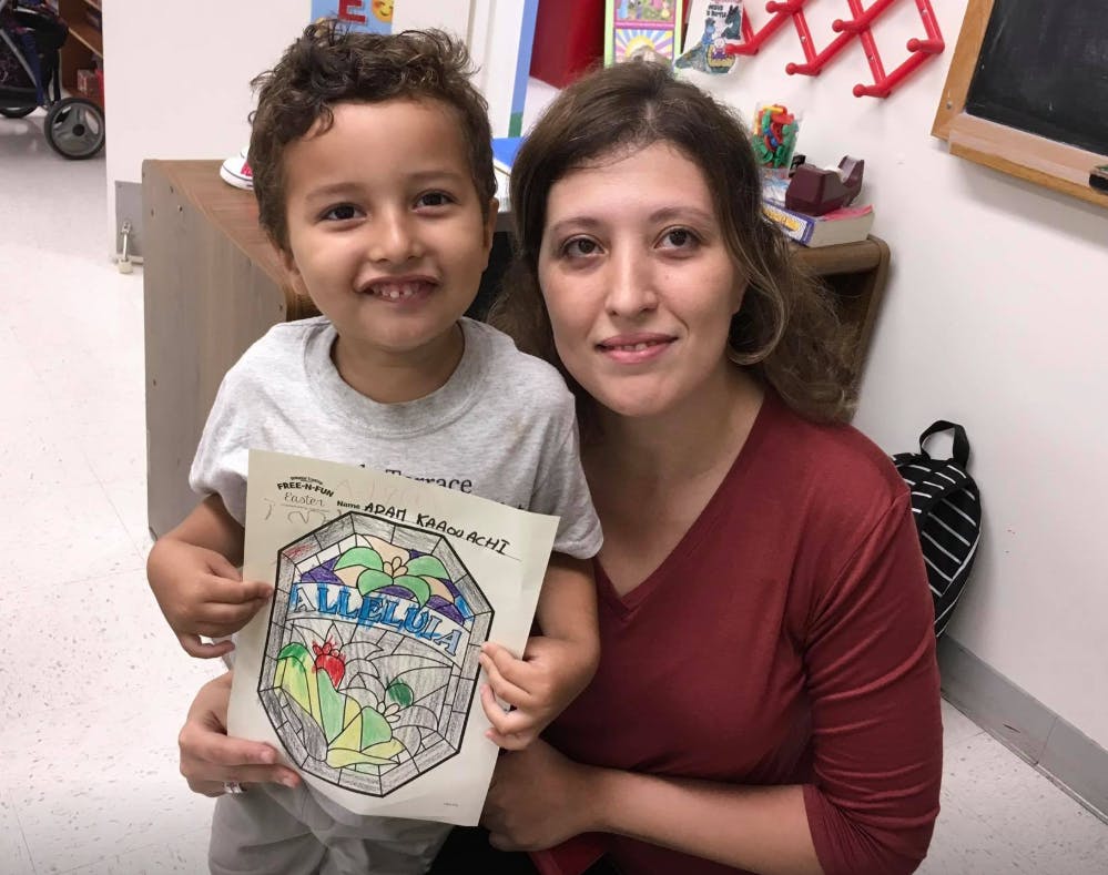 Adult and child holding up a drawing