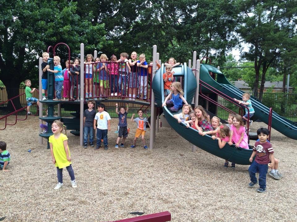 Children playing on a playground structure with slides