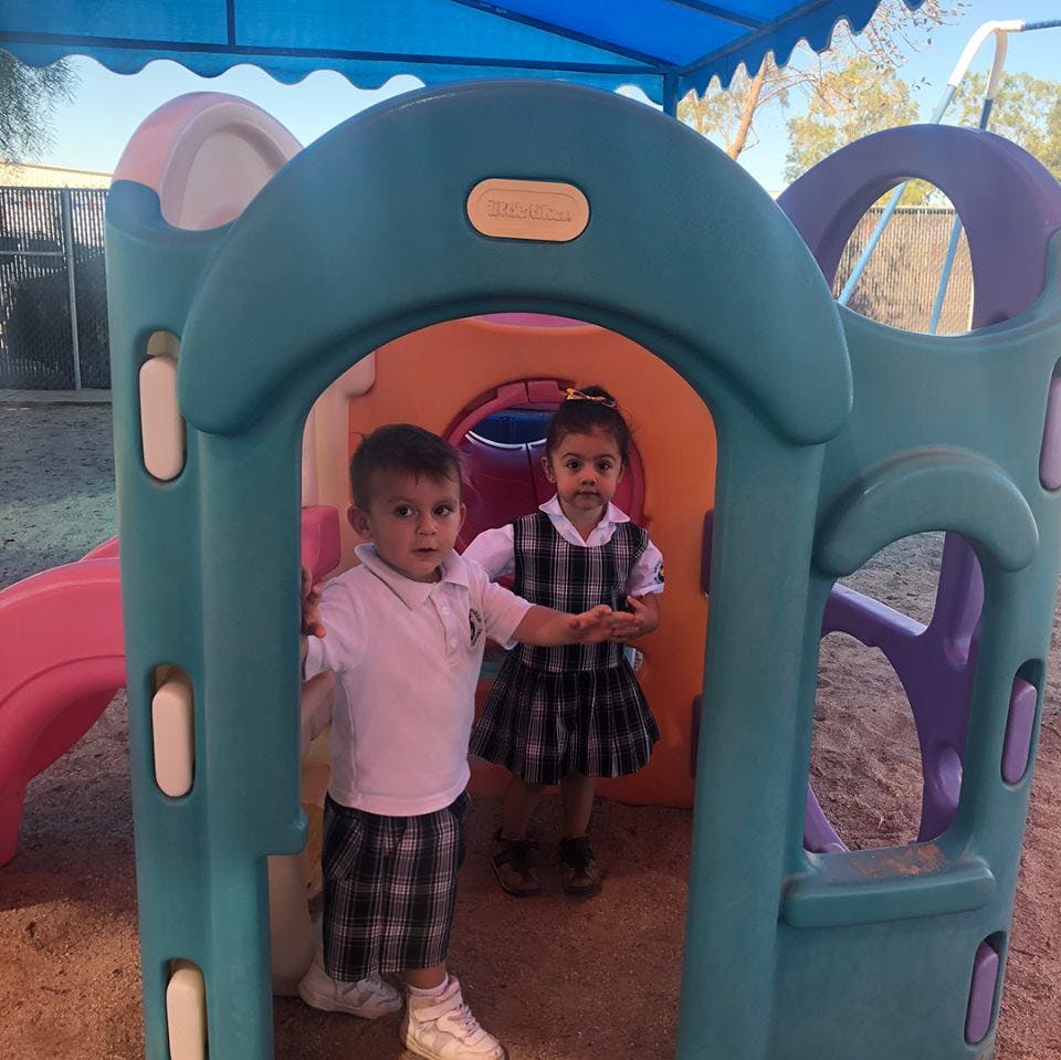 Two children standing in a play structure