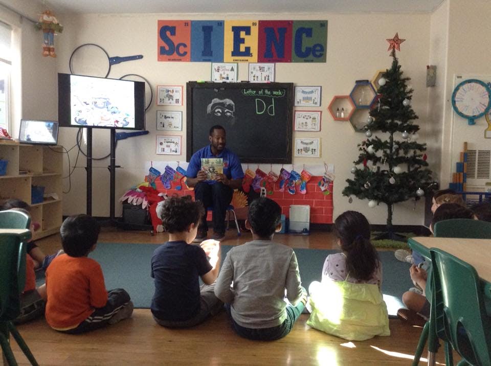 Adult reading to children in a classroom