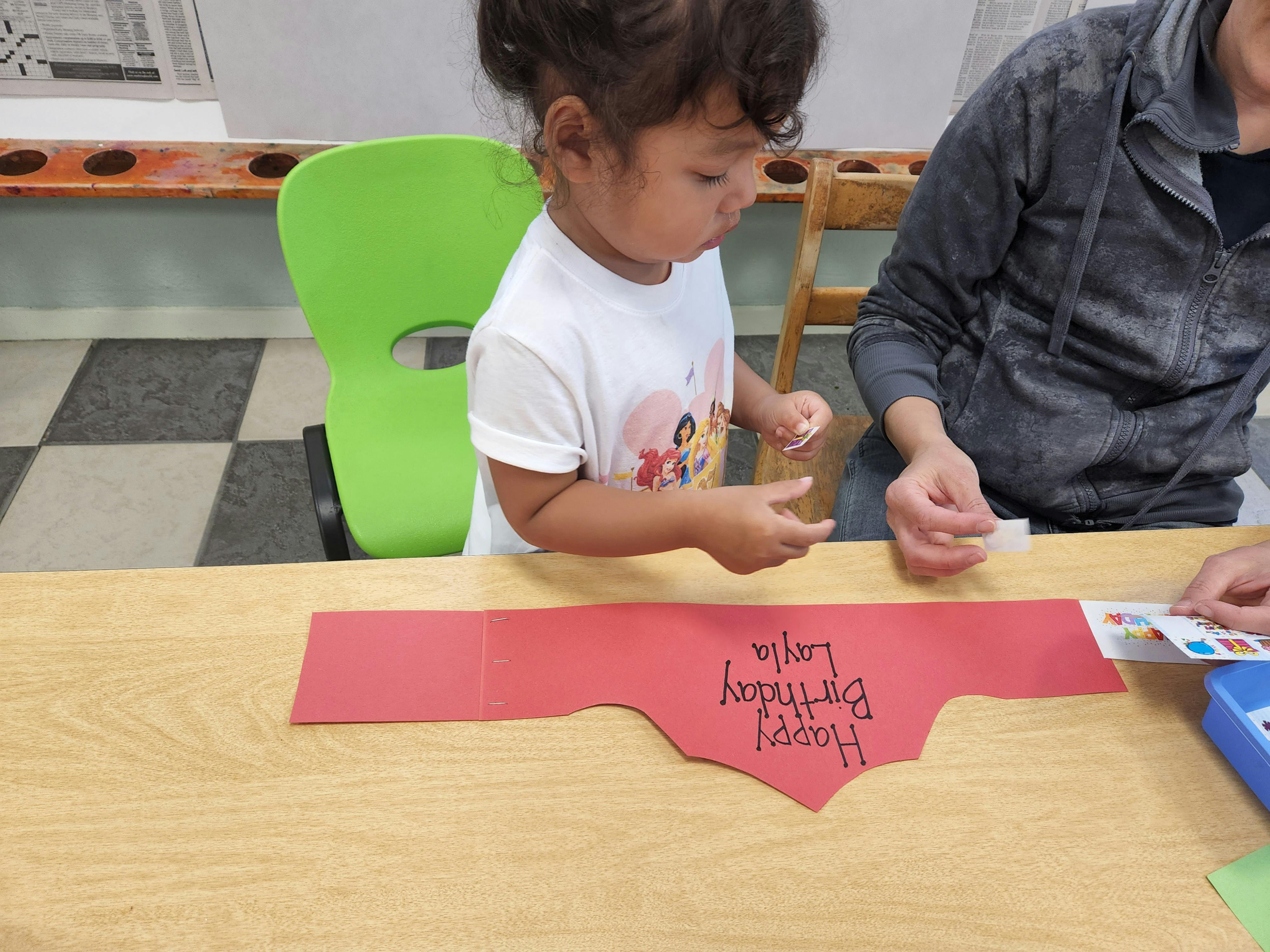 Child and person crafting at a table