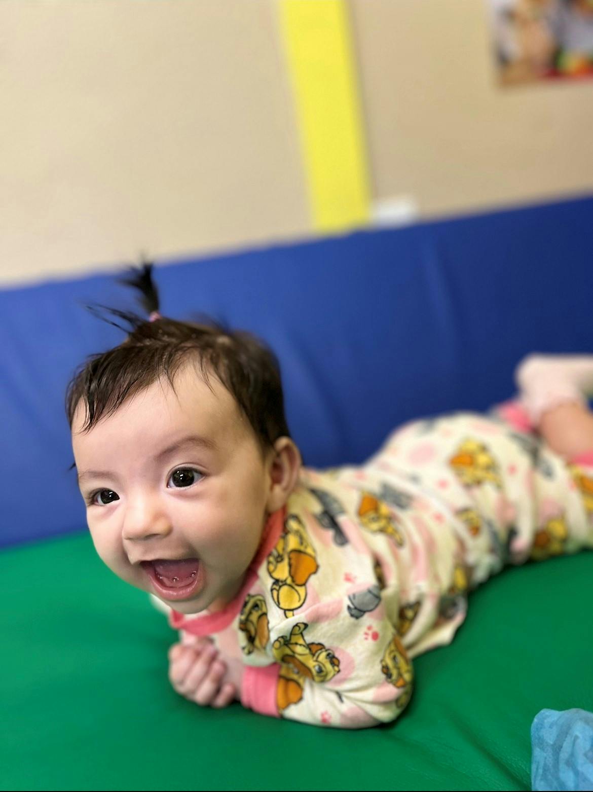 Child in patterned pajamas lying on stomach