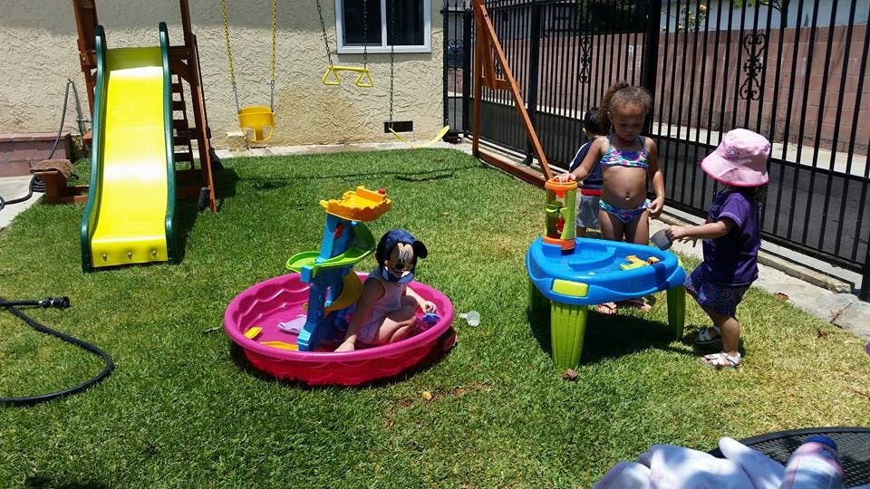 Children playing with water toys in a backyard