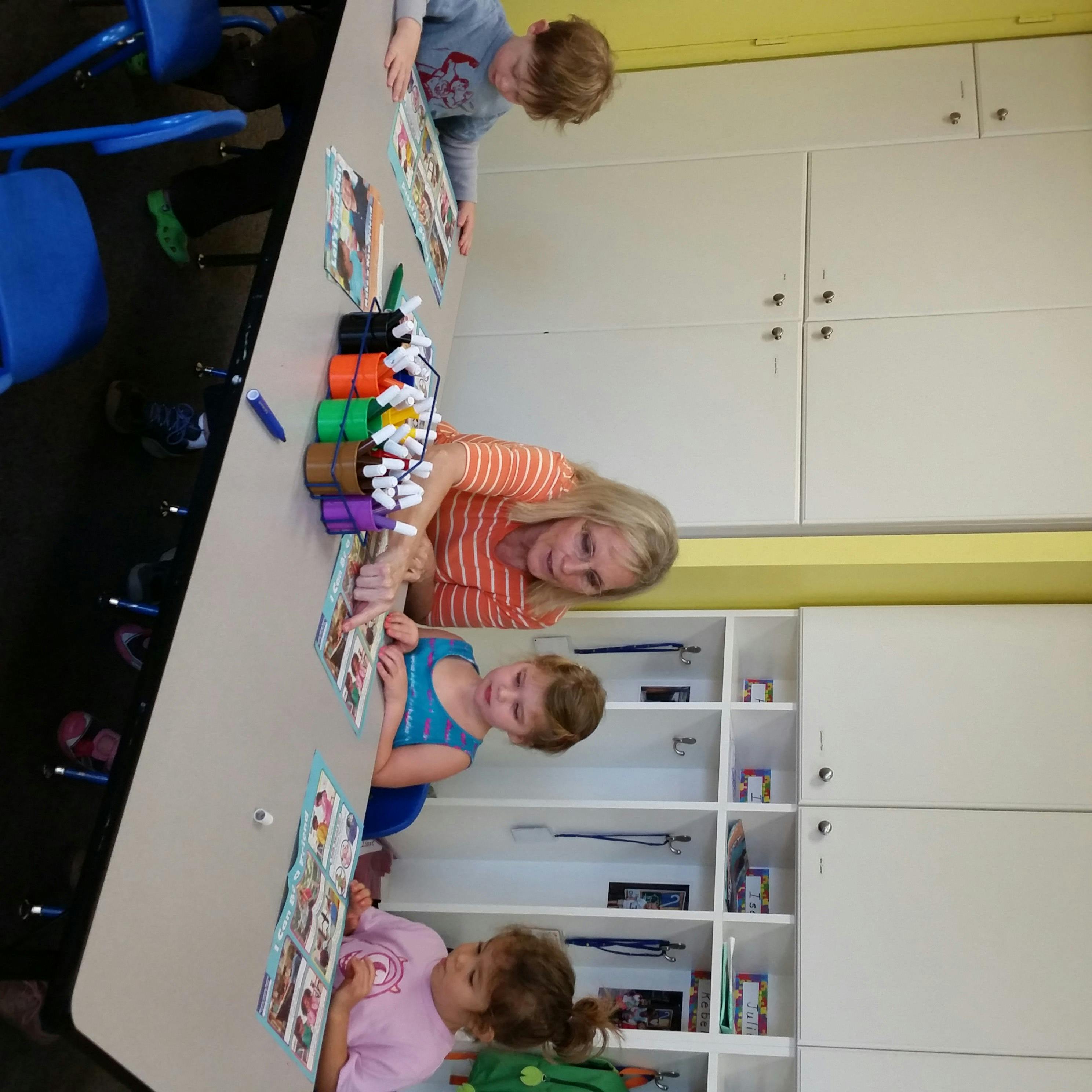 Adult and three children at a table with art supplies