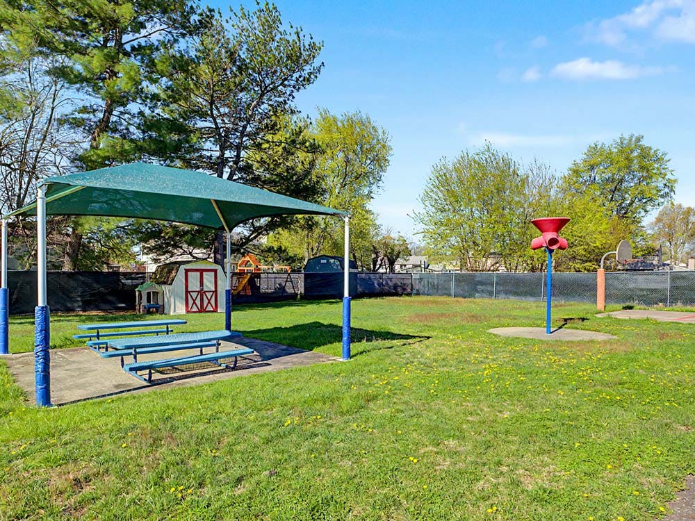 Playground area with a covered picnic table and various play structures