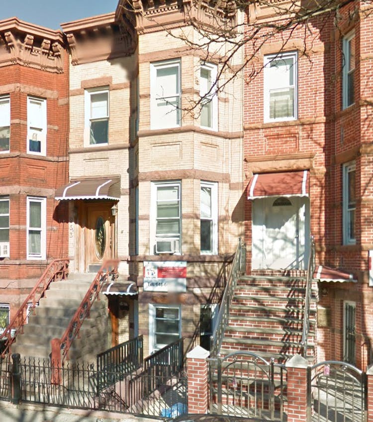 Row of brick townhouses with stoops and awnings