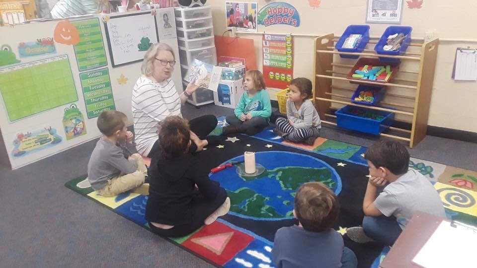 Person reading to children in a classroom