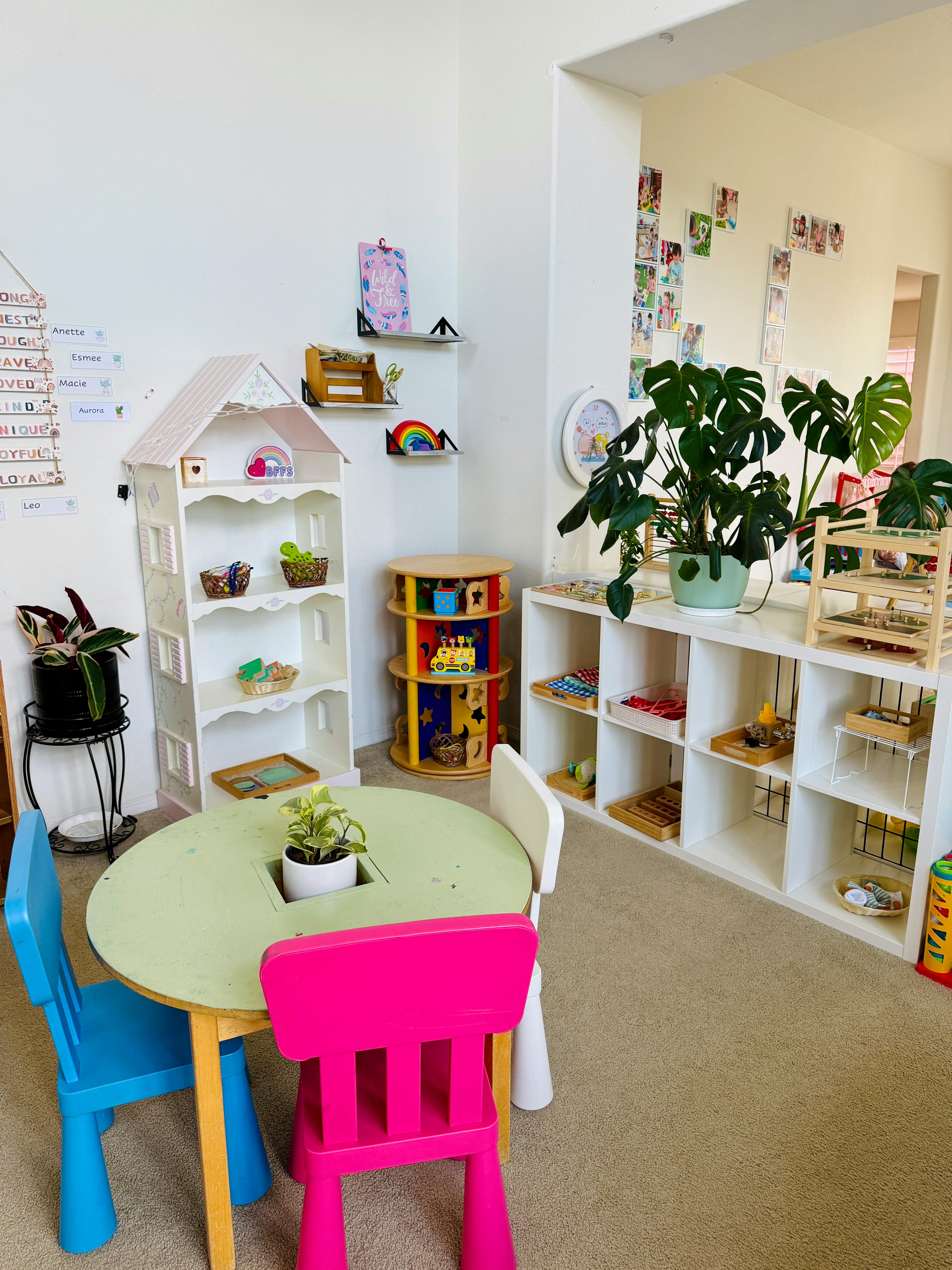 Children's classroom with small table and chairs, shelves with toys and plants