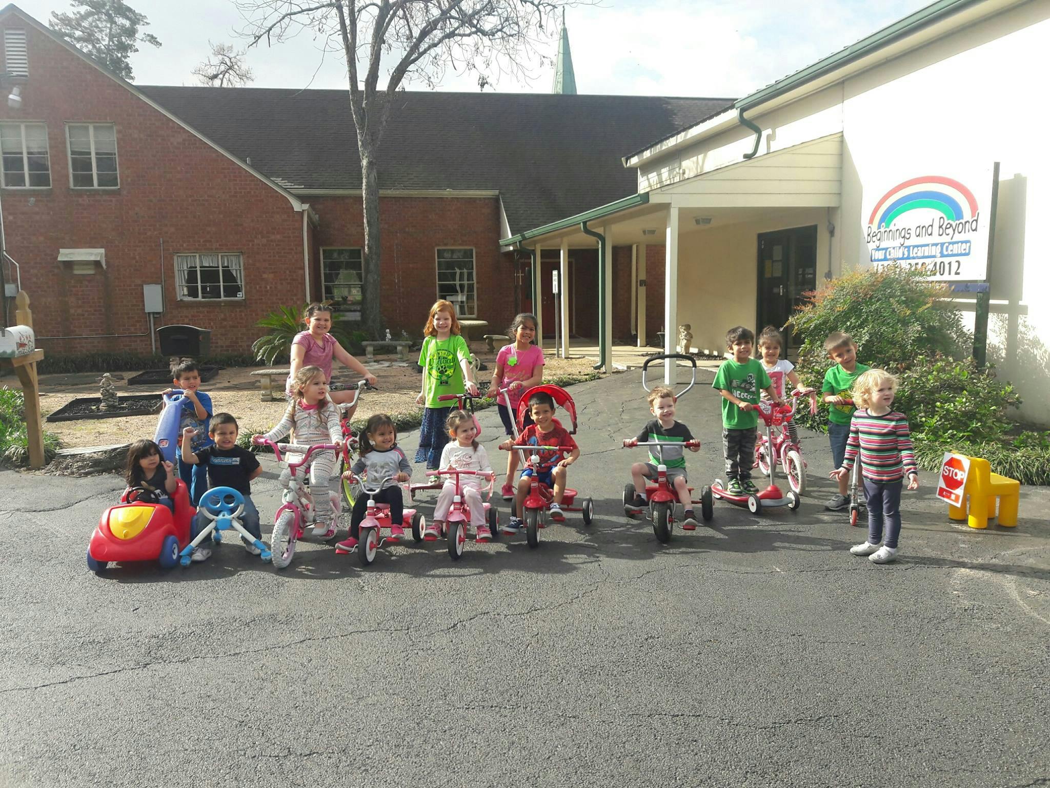 Group of children with tricycles and ride-on toys outdoors